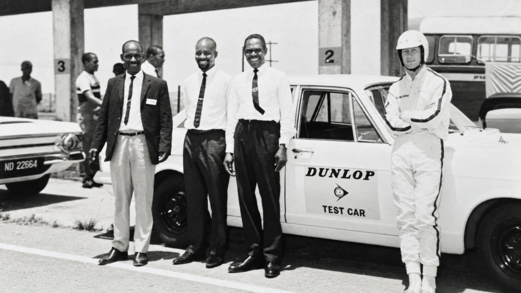 Obert Nkosi standing with colleagues beside a Dunlop test car in Durban
